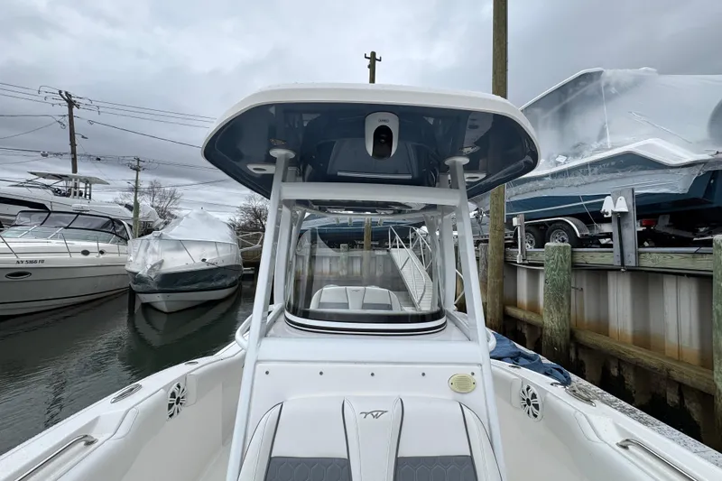 Slide: The Image of 2018 Tidewater 252 LXF boat docked, surrounded by other vessels under cloudy skies. - 12