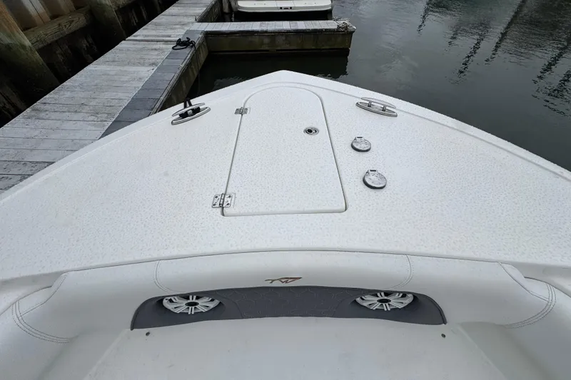 Slide: The Image of 2018 Tidewater 252 LXF boat bow view at dock, featuring sleek design and storage hatch. - 16