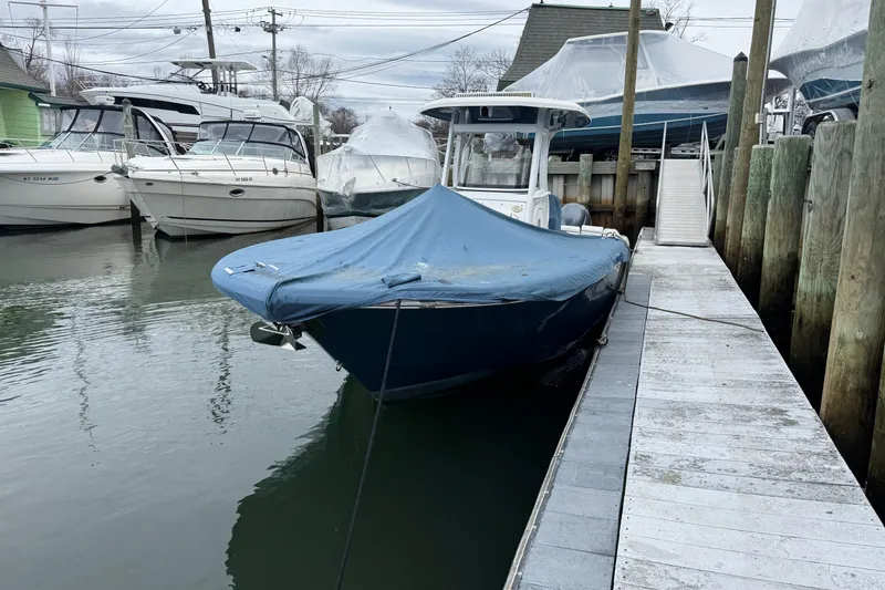 Slide: The Image of 2018 Tidewater 252 LXF boat docked with cover, surrounded by other boats. - 22