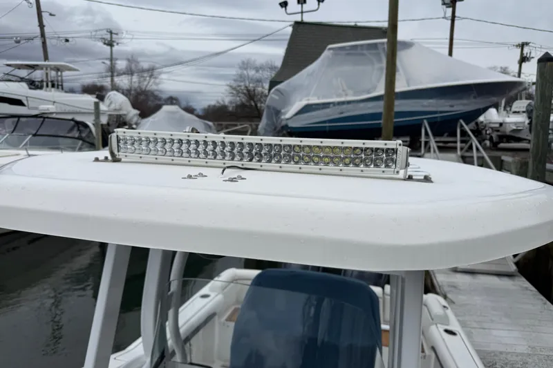 Slide: The Image of 2018 Tidewater 252 LXF boat with LED light bar on top, docked in marina. - 23