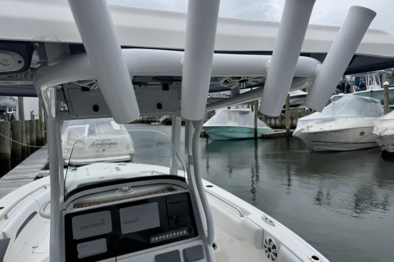 Slide: The Image of 2018 Tidewater 252 LXF boat docked, featuring Garmin electronics and rod holders. - 24