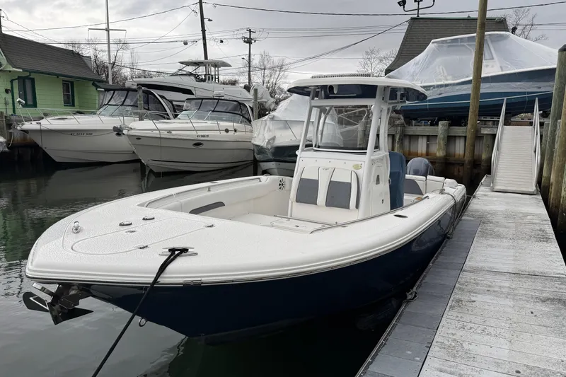 Slide: The Image of 2018 Tidewater 252 LXF boat docked at a marina, surrounded by other vessels. - 3