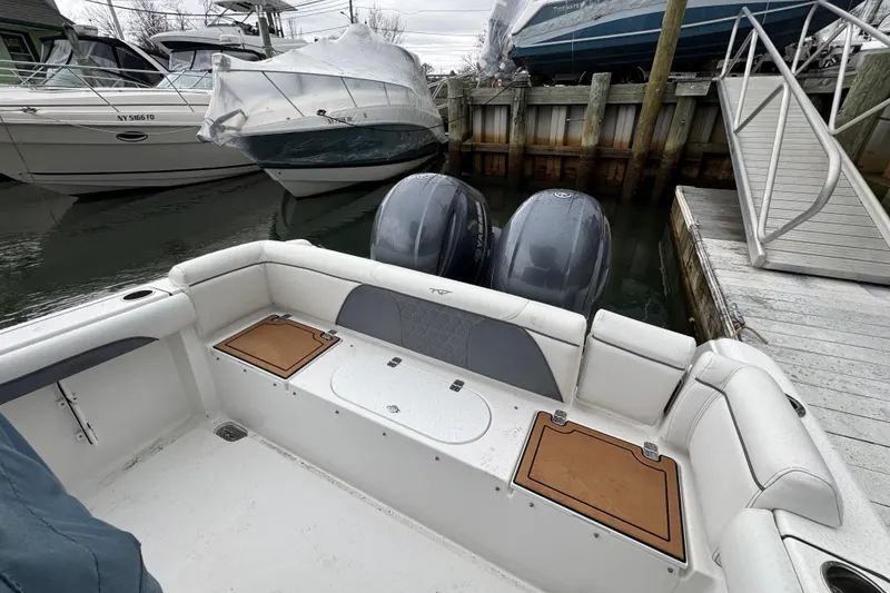 Slide: The Image of 2018 Tidewater 252 LXF boat docked, featuring dual engines and spacious seating area. - 4