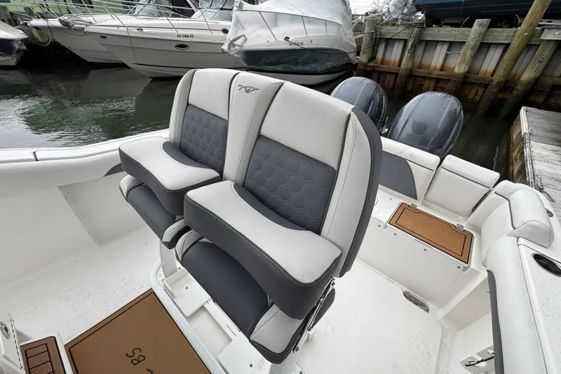 Slide: The Image of 2018 Tidewater 252 LXF boat interior with dual seats and twin engines at dock. - 5