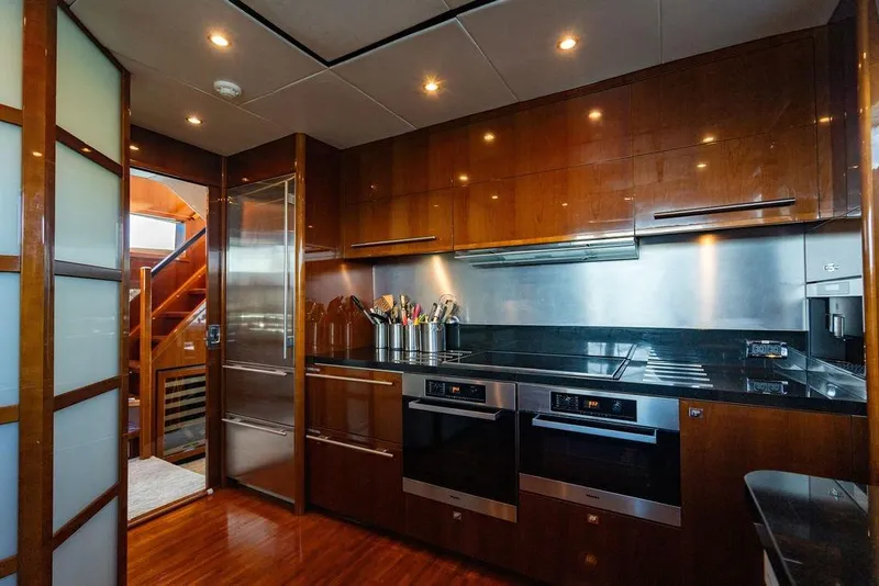 Slide: The Image of Luxurious kitchen interior on a 2010 Princess 95 Motor Yacht, featuring modern appliances and wood finishes. - 3