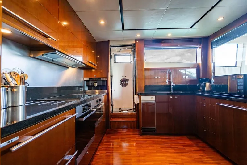 Slide: The Image of Luxurious kitchen interior on a 2010 Princess 95 Motor Yacht, featuring sleek wood cabinetry. - 75