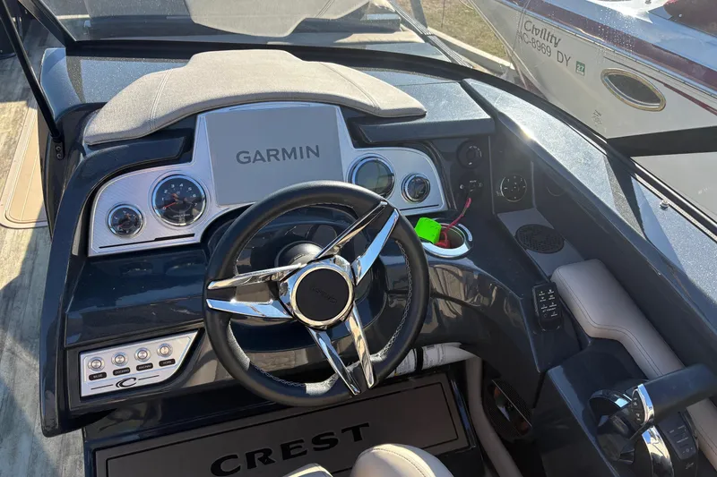 Slide: The Image of Cockpit of 2022 Crest Continental 250 boat with Garmin navigation system and sleek steering wheel. - 7