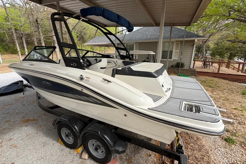Slide: The Image of 2017 Sea Ray SPX 190 boat on trailer under shelter, near house and trees. - 2