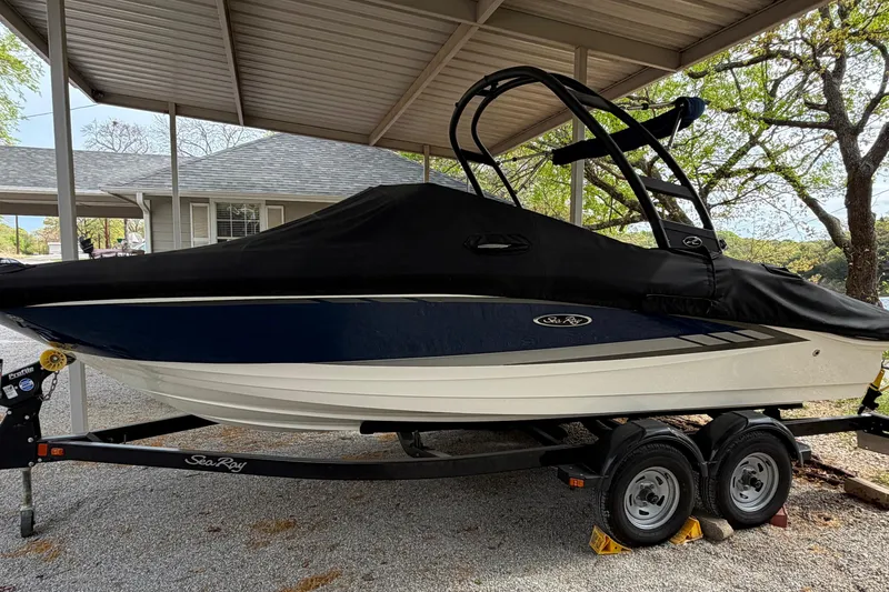 Slide: The Image of 2017 Sea Ray SPX 190 boat with cover, parked on a trailer under a shelter. - 4