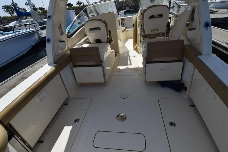 Slide: The Image of 2017 Scout 275 Dorado boat interior with seating and storage, docked at marina. - 11