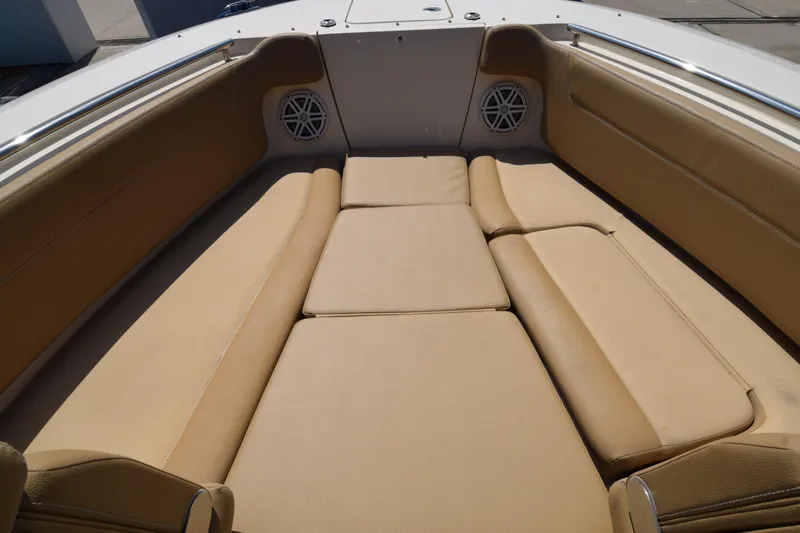 Slide: The Image of 2017 Scout 275 Dorado boat interior with tan cushioned seating and built-in speakers. - 2