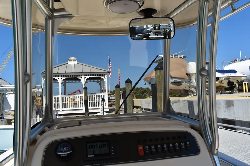 Slide: The Image of 2017 Grady-White Fisherman 257 boat interior with helm and seating, docked on calm water. - 17