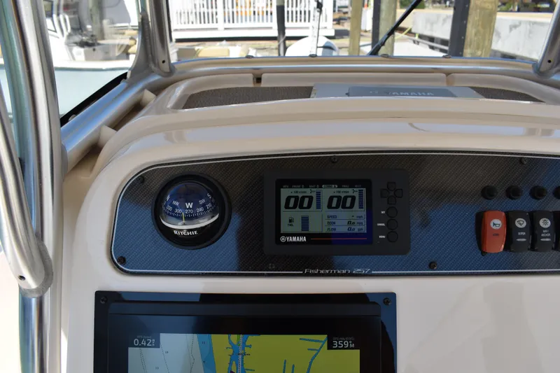 Slide: The Image of 2017 Grady-White Fisherman 257 boat interior with cushioned seating and steering wheel. - 18