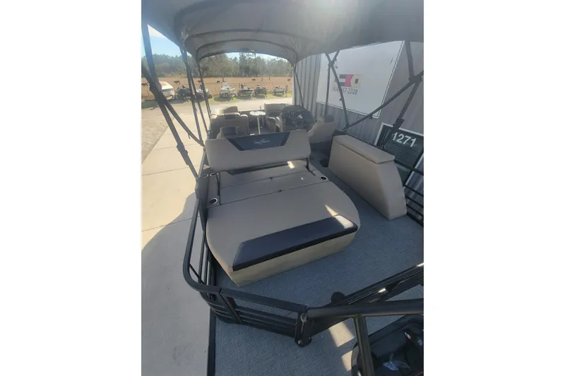 Slide: The Image of 2026 SunChaser Geneva Cruise 24 LR DH Sport pontoon boat interior with seating and canopy. - 6