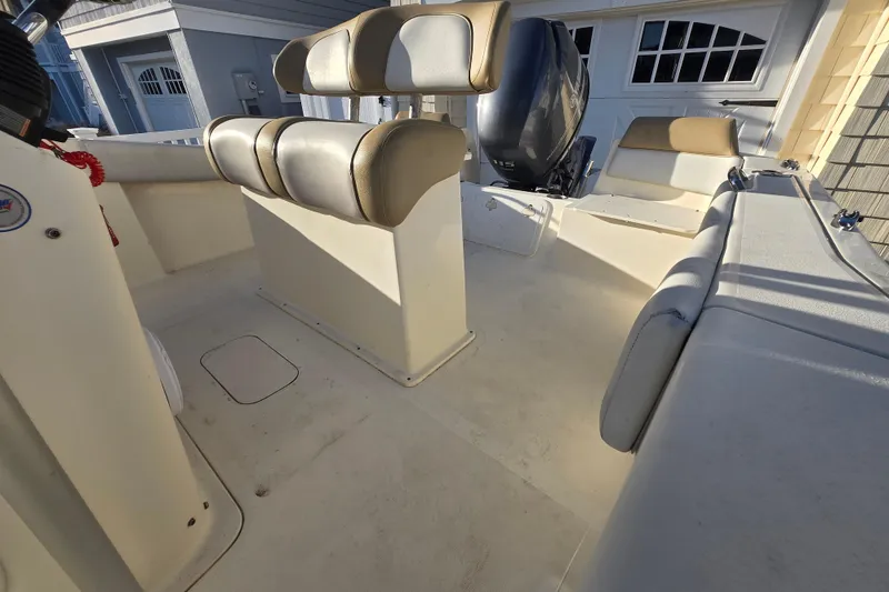 Slide: The Image of 2015 Scout 195 Sportfish boat interior with seating and motor, in a sunny setting. - 11