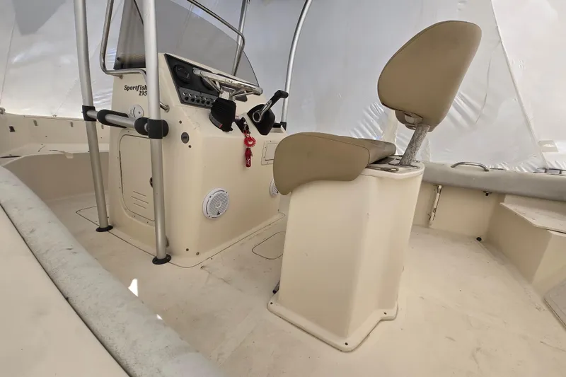 Slide: The Image of 2015 Scout 195 Sportfish boat with Yamaha outboard motor on a trailer in a residential driveway. - 2