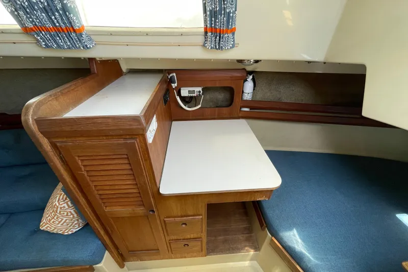 Slide: The Image of Interior of a 1982 O'Day 34 sailboat with blue seating and wooden cabinetry. - 19