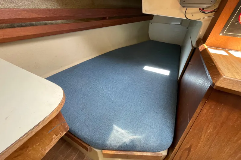 Slide: The Image of Interior of 1982 O'Day 34 sailboat with wooden cabinetry and blue seating. - 21