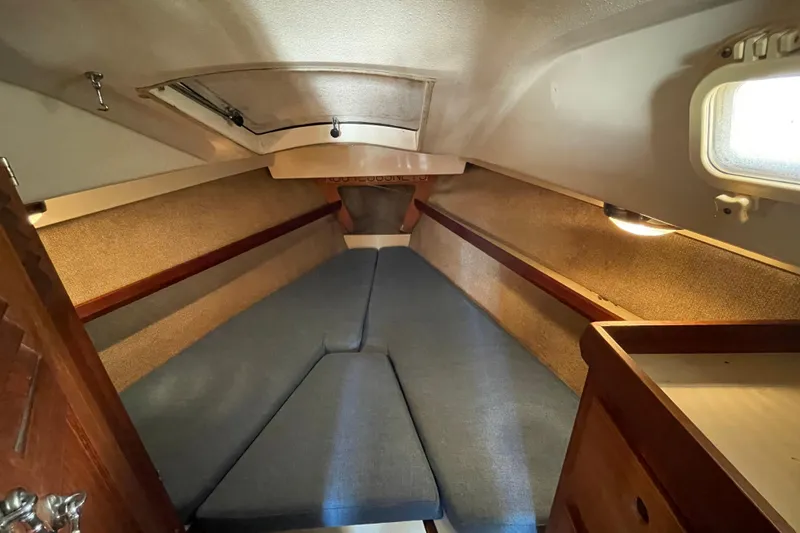 Slide: The Image of Interior of 1982 O'Day 34 sailboat with blue cushions and patterned pillows. - 26