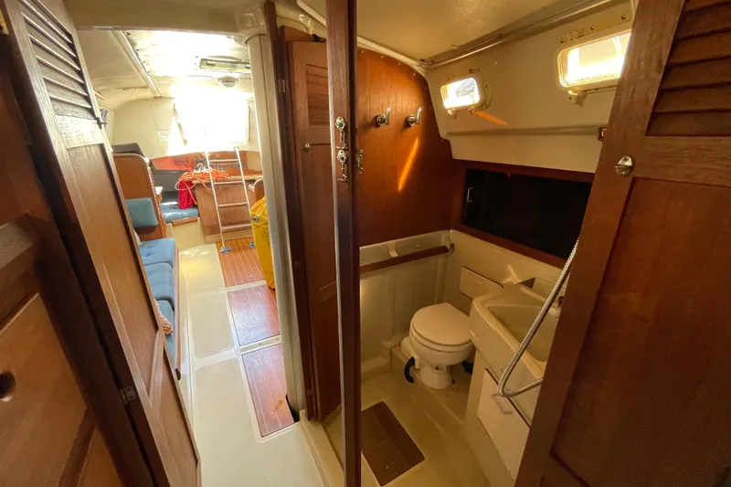 Slide: The Image of Interior of a 1982 O'Day 34 sailboat with wood paneling and blue cushions. - 27