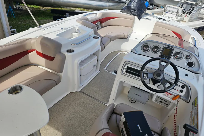 Slide: The Image of 2014 Hurricane SunDeck Sport 203 OB boat interior with steering wheel and seating area. - 8
