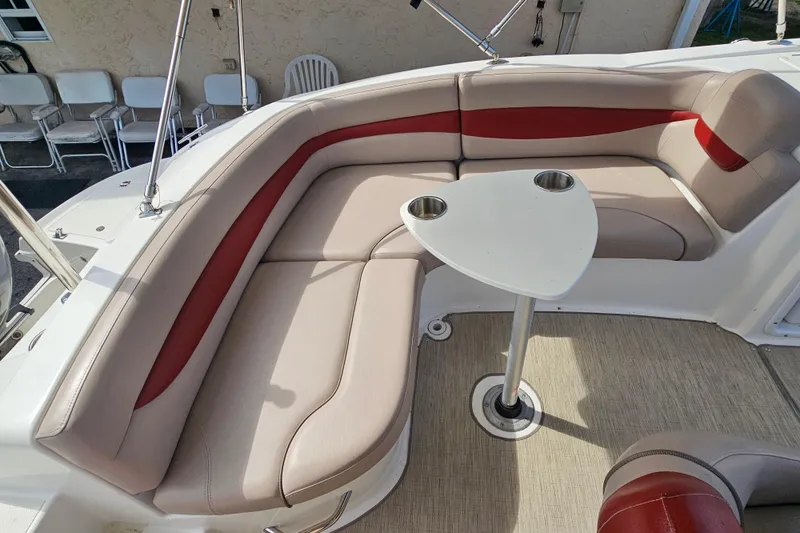 Slide: The Image of 2014 Hurricane SunDeck Sport 203 OB boat interior with beige and red seating, small table. - 9