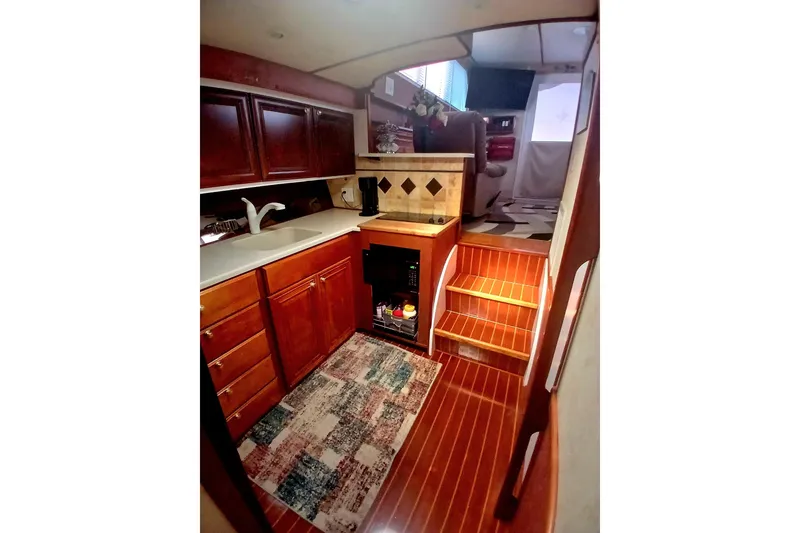 Slide: The Image of Interior of 1976 Viking 40 Sedan Diesel with wooden cabinetry and compact kitchen area. - 12