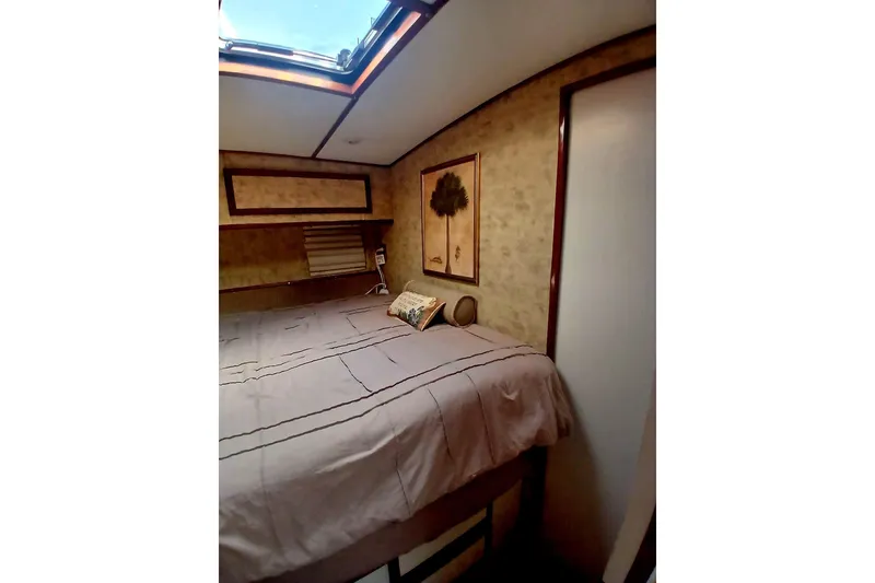 Slide: The Image of Cozy bedroom interior of 1976 Viking 40 Sedan Diesel boat with skylight and wall art. - 24