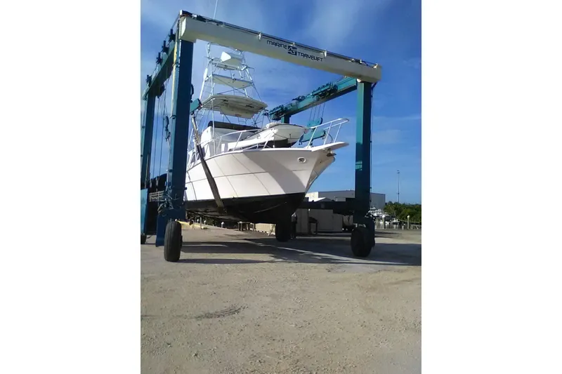 Slide: The Image of 1976 Viking 40 Sedan Diesel boat on a travel lift under a clear blue sky. - 29