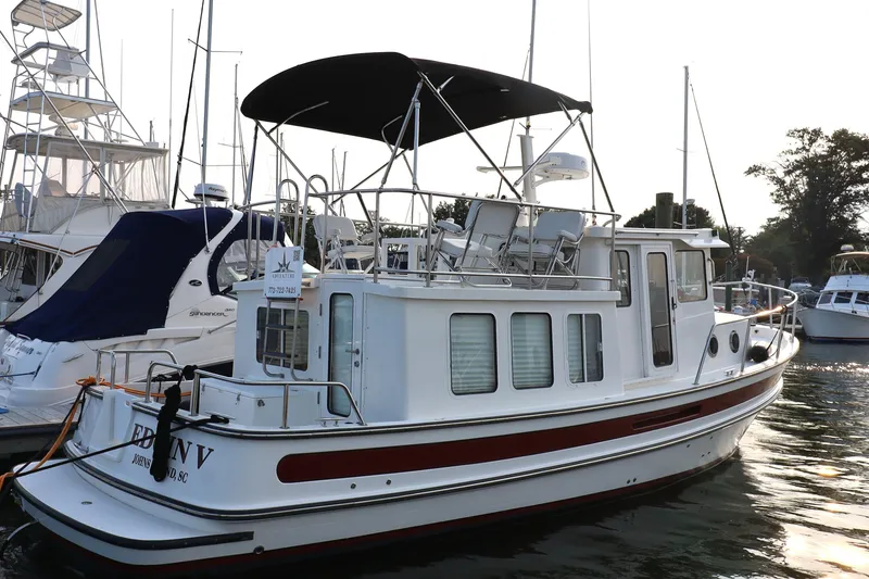 Slide: The Image of 2007 Nordic Tug 32 docked at marina, featuring classic design and spacious deck. - 0