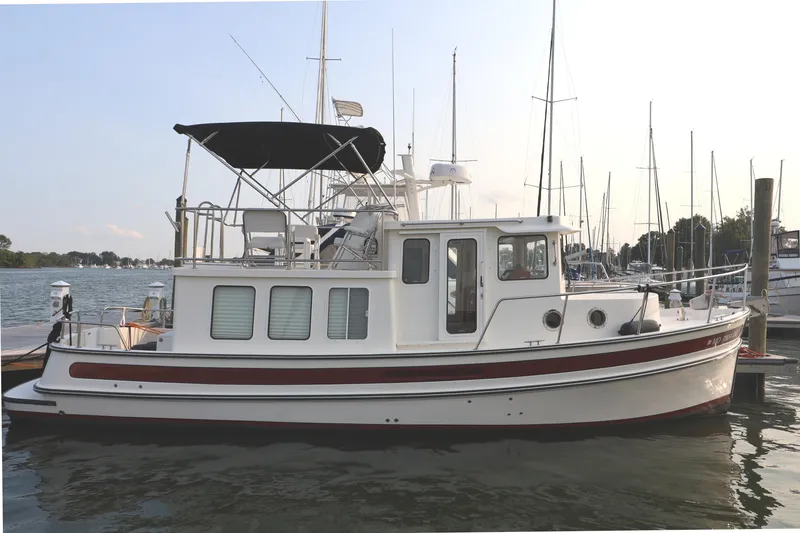 Slide: The Image of 2007 Nordic Tug 32 docked at marina, featuring classic design and spacious deck. - 1