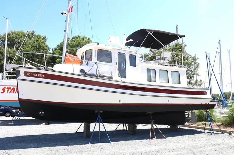 Slide: The Image of 2007 Nordic Tug 32 boat on stands in a marina setting. - 14