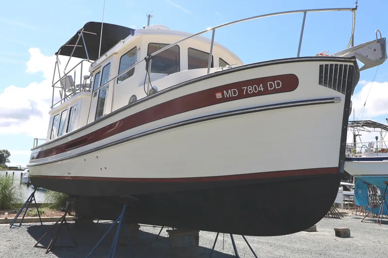 Slide: The Image of 2007 Nordic Tug 32 boat on stands, side view, clear sky background. - 16