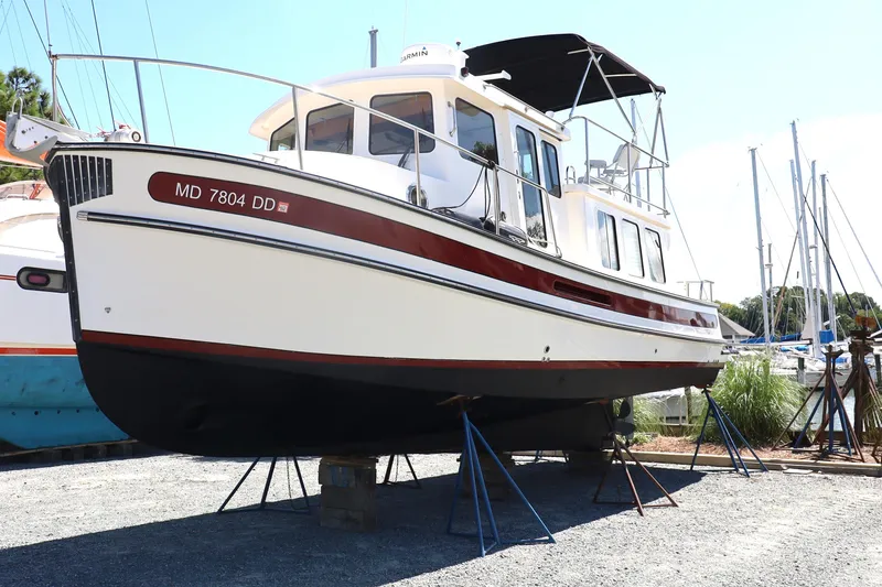 Slide: The Image of 2007 Nordic Tug 32 boat on stands in a marina setting. - 18
