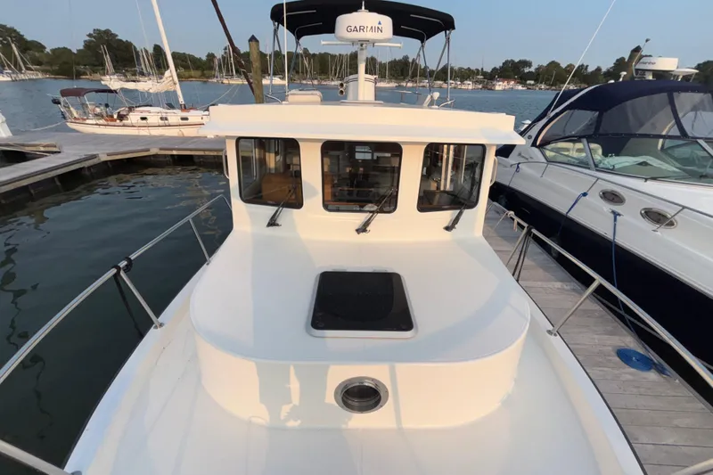 Slide: The Image of 2007 Nordic Tug 32 docked at marina, surrounded by other boats. - 25