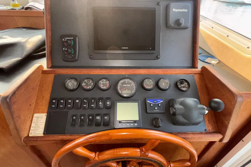 Slide: The Image of 2007 Nordic Tug 32 helm with gauges, controls, and navigation equipment. - 7