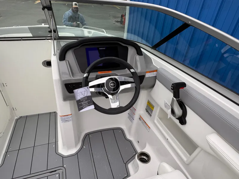 Slide: The Image of 2025 Chaparral 23 SSi OB boat cockpit with steering wheel and control panel. - 1