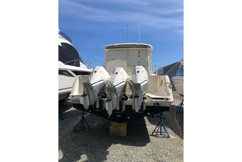 Slide: The Image of 2020 Boston Whaler 345 Conquest with triple outboard engines, docked on land. - 3