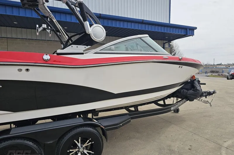 Slide: The Image of 2013 MasterCraft X-10 boat on trailer, featuring sleek design and vibrant red accents. - 10