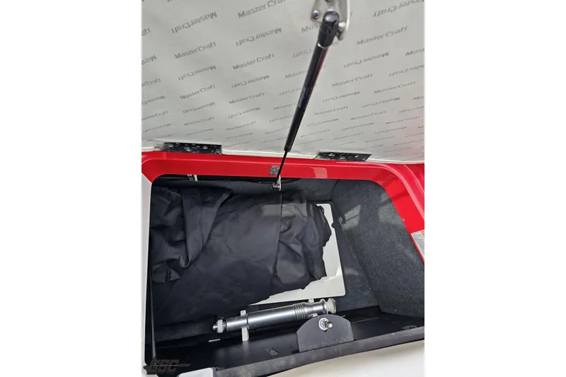 Slide: The Image of Open storage compartment of 2013 MasterCraft X-10 boat with black cover inside. - 106