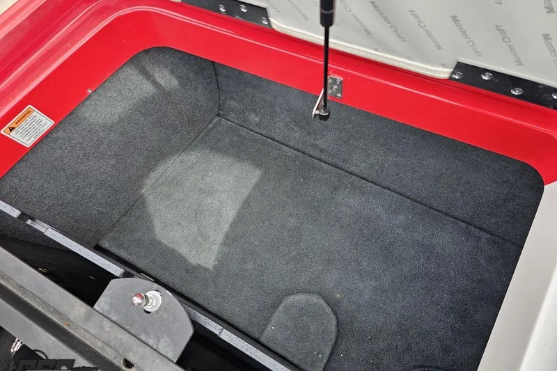Slide: The Image of 2013 MasterCraft X-10 storage compartment with red trim and carpeted interior. - 108