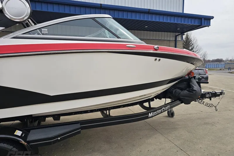 Slide: The Image of 2013 MasterCraft X-10 boat on trailer, featuring sleek design and red accents. - 14