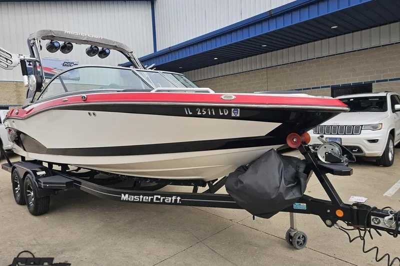 Slide: The Image of 2013 MasterCraft X-10 boat on trailer, parked outdoors near a building. - 17