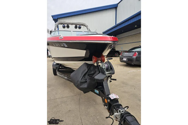 Slide: The Image of 2013 MasterCraft X-10 boat on trailer, parked outside a building. - 19