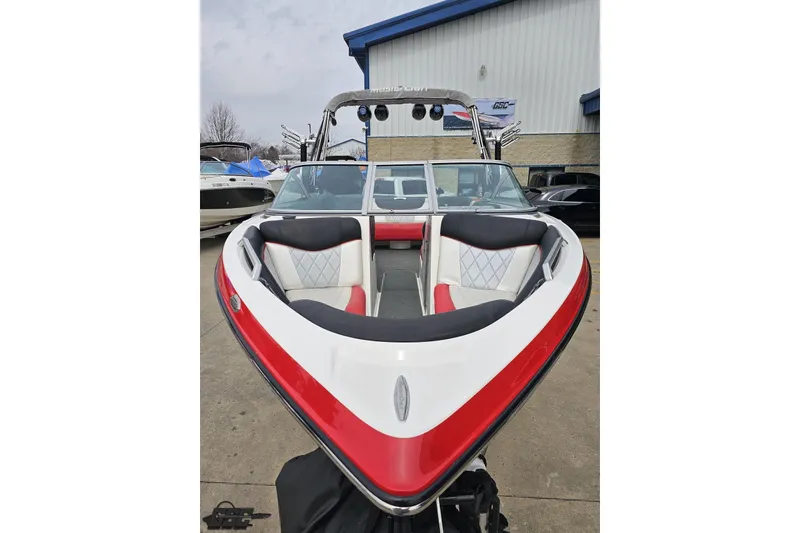 Slide: The Image of 2013 MasterCraft X-10 boat with red and white interior, parked outdoors. - 20