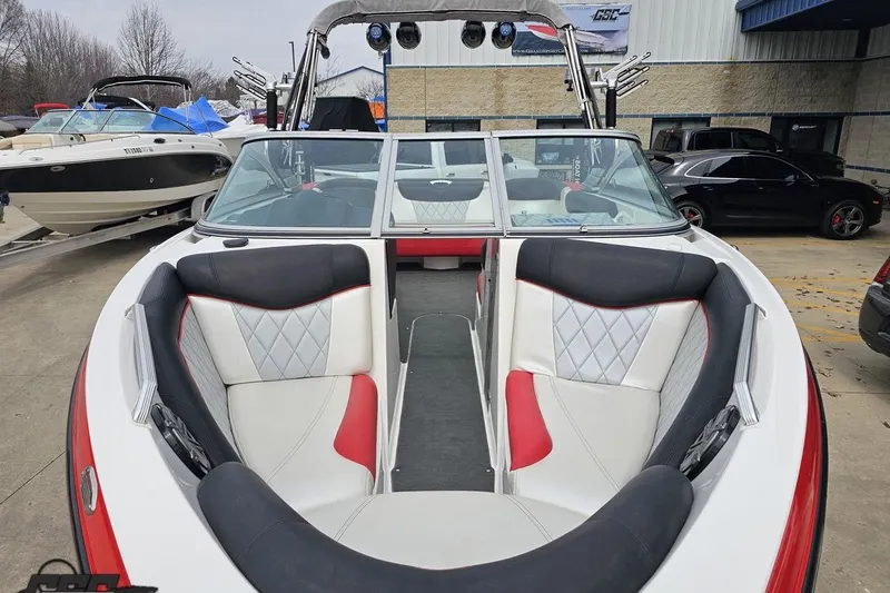 Slide: The Image of 2013 MasterCraft X-10 boat with red and white interior, parked outdoors. - 21