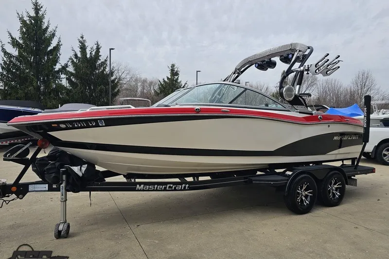 Slide: The Image of 2013 MasterCraft X-10 boat on trailer, featuring sleek design and vibrant red accents. - 23