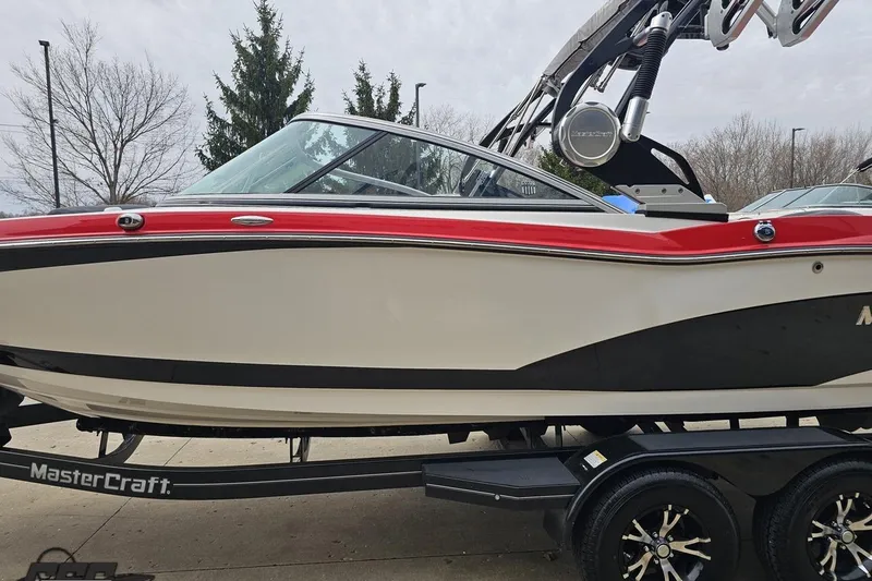 Slide: The Image of 2013 MasterCraft X-10 boat with red and black accents on a trailer. - 25
