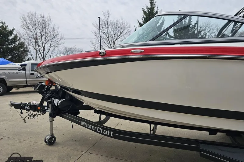 Slide: The Image of 2013 MasterCraft X-10 boat on trailer, featuring sleek design and red accents. - 26