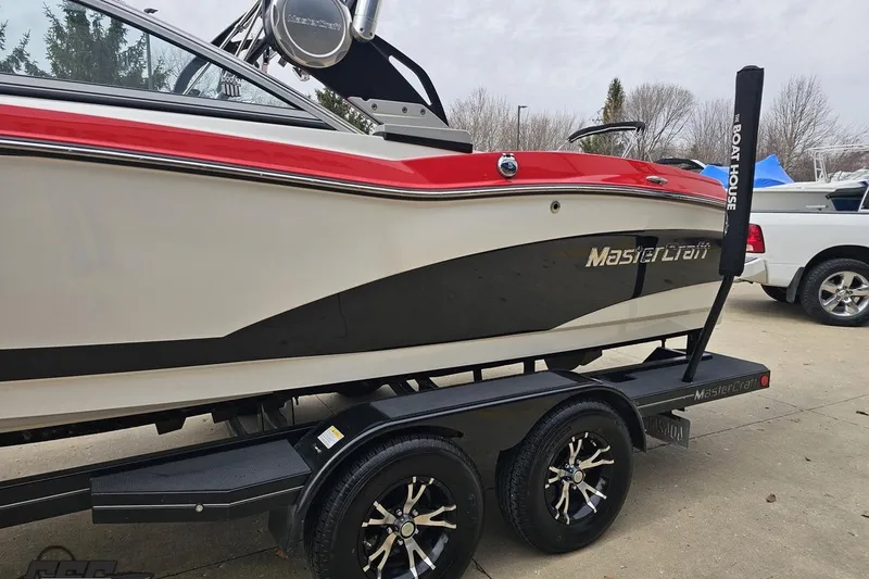 Slide: The Image of 2013 MasterCraft X-10 boat on trailer, featuring sleek design and vibrant red accents. - 27